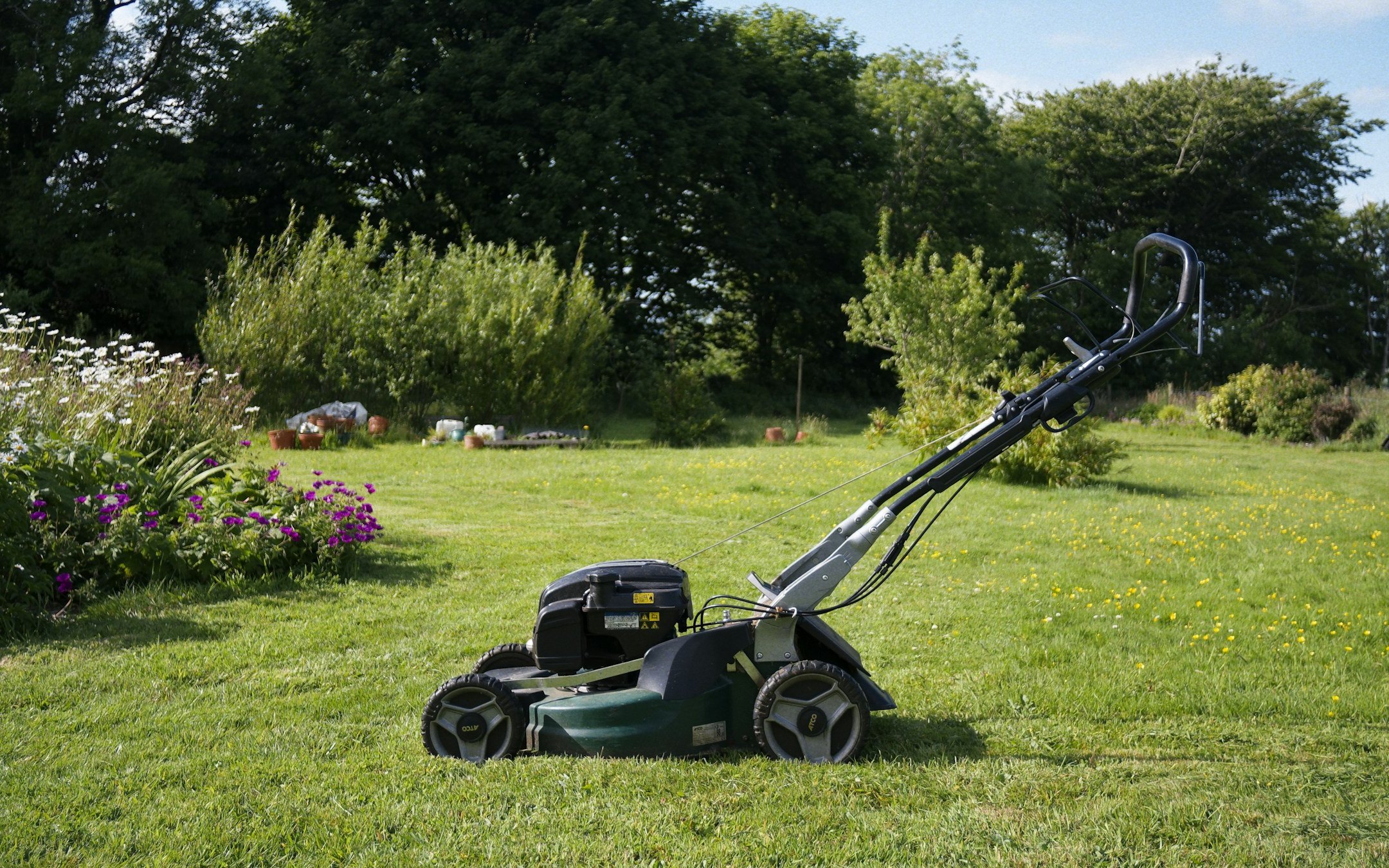 An electric mower on a striped lawn